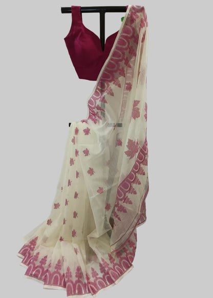 A cream-colored saree with pink floral and border patterns, paired with a deep pink sleeveless blouse, displayed on a black hanger against a draped cream fabric backdrop.