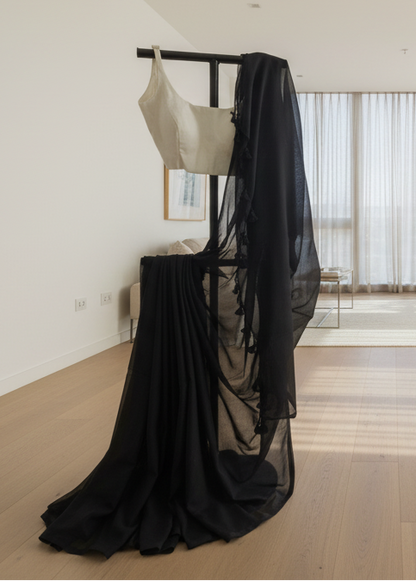 Black and white dress on a rack in a minimalistic room with large windows.
