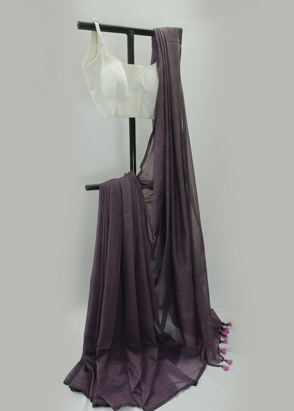 Purple saree with a white blouse on a black stand against a plain background