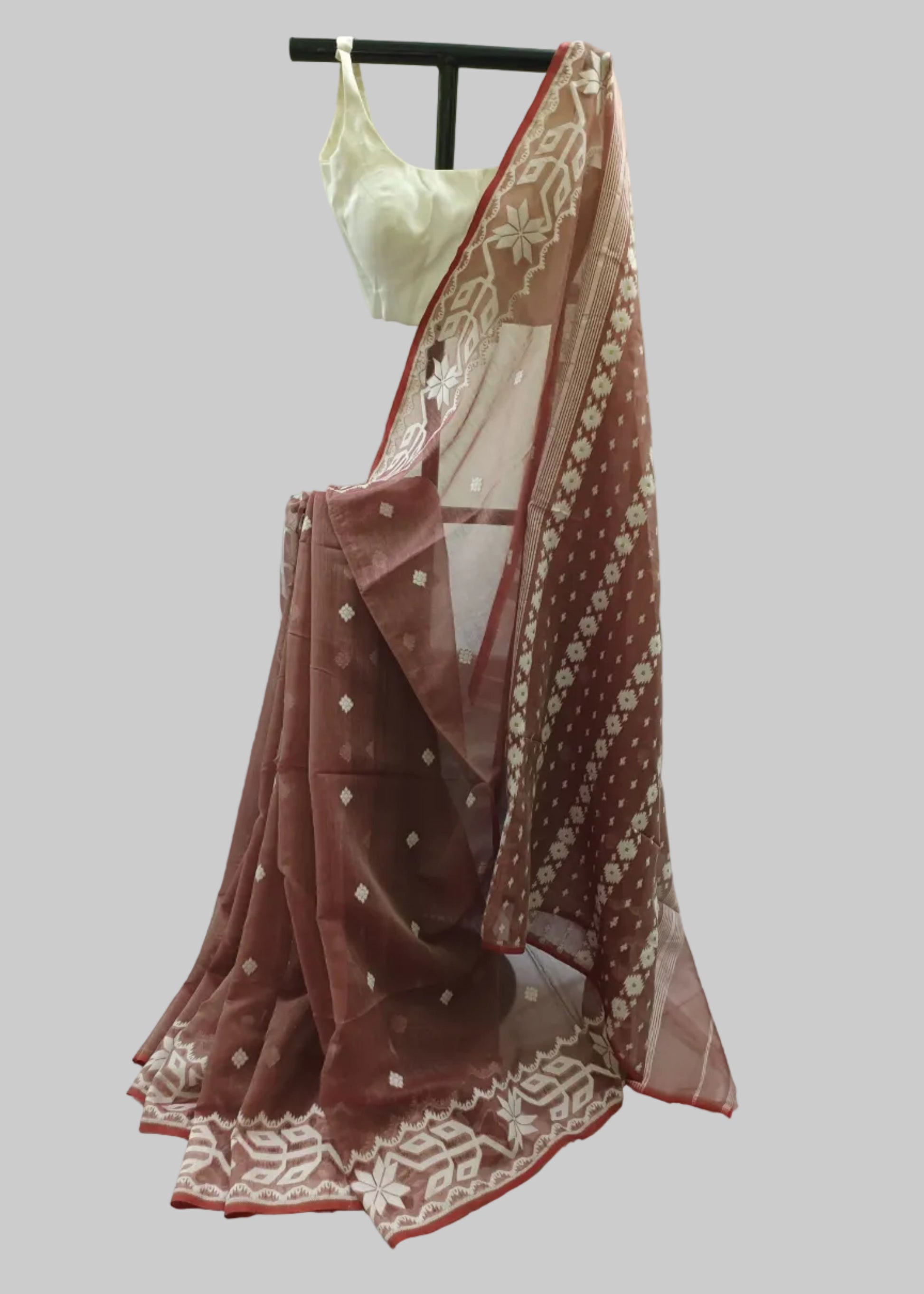 Brown saree with white patterns on a mannequin against a white background