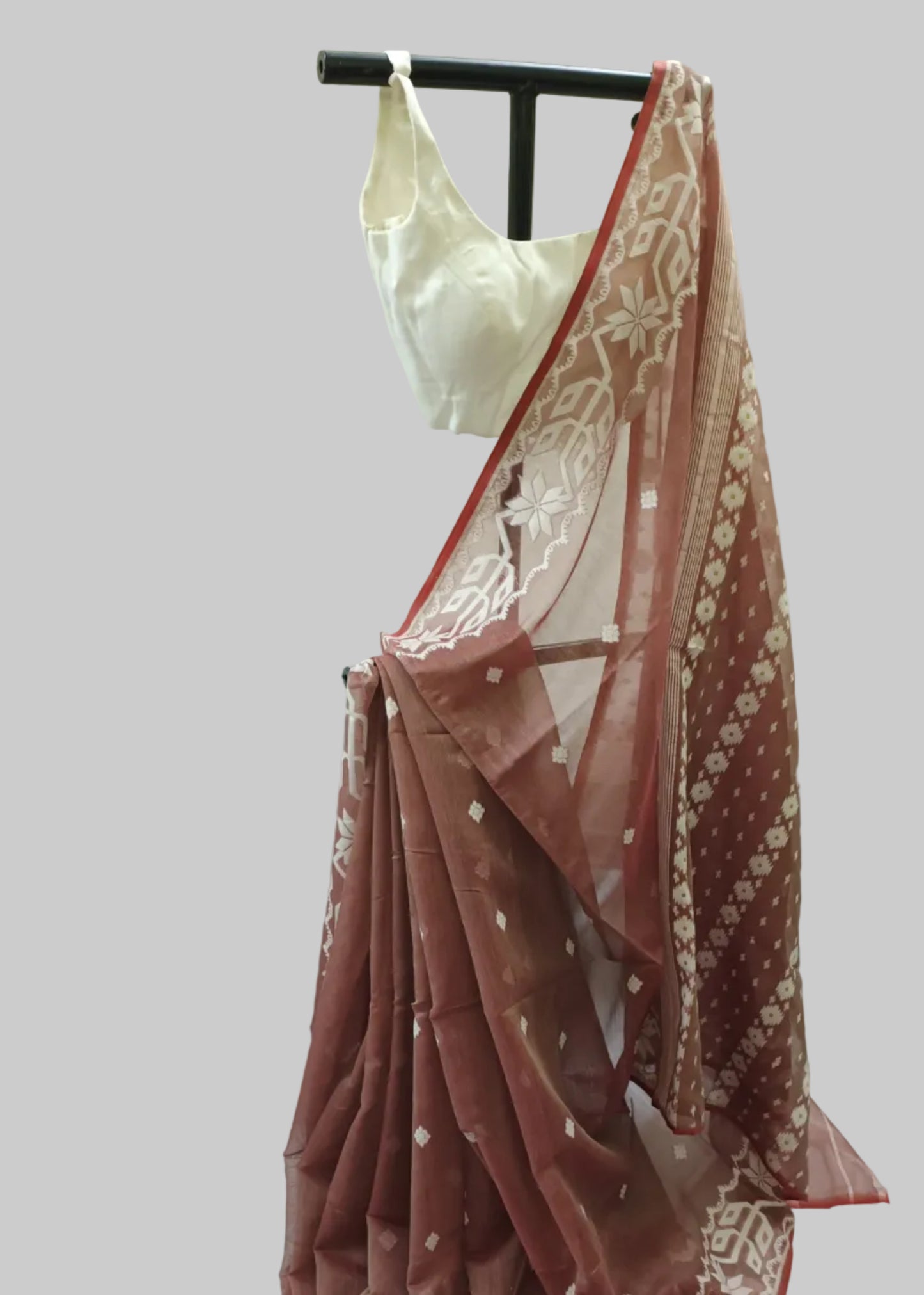 Red saree with white patterns on a mannequin against a white background