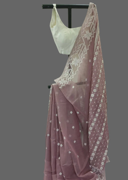 White lace top and pink saree with white patterns on a mannequin against a white background