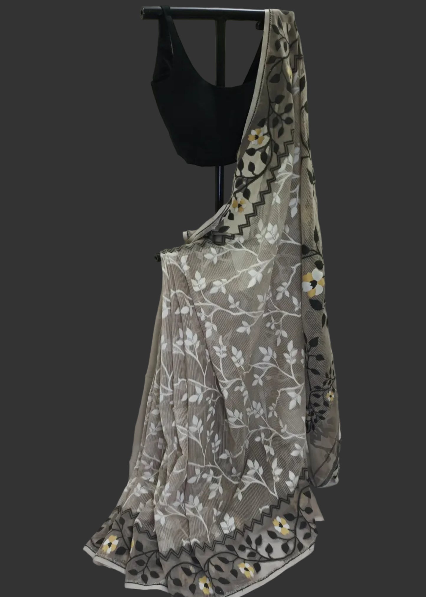 Black crop top with a floral-patterned gray skirt on a mannequin against a white backdrop