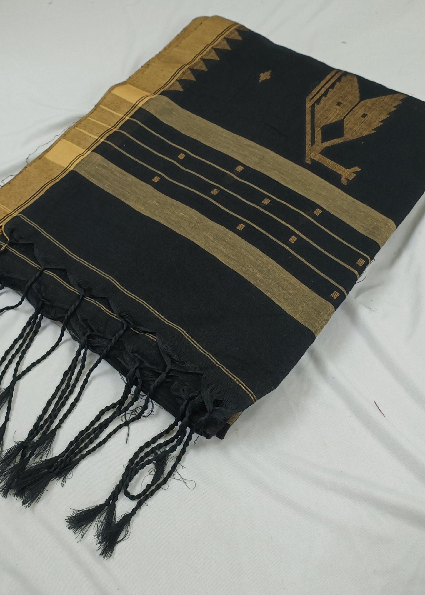 Black and gold patterned scarf with fringes on a white background