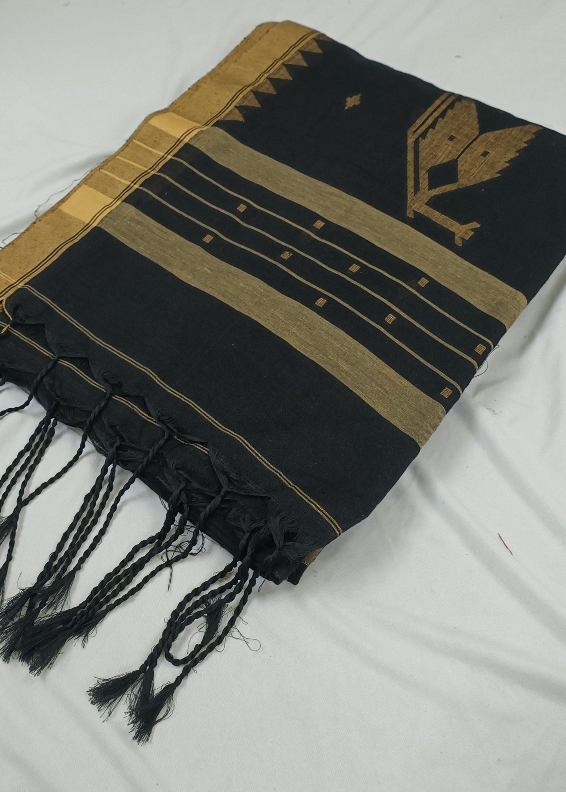 Black and gold patterned scarf with fringes on a white background