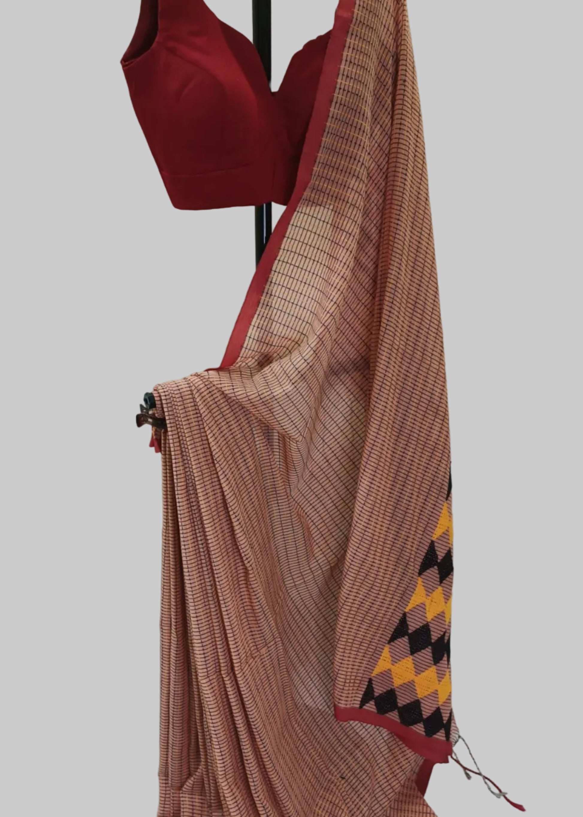Red blouse and brown saree with geometric pattern on a white background