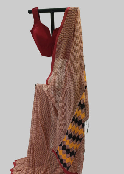 Traditional saree with a red blouse draped over a white background