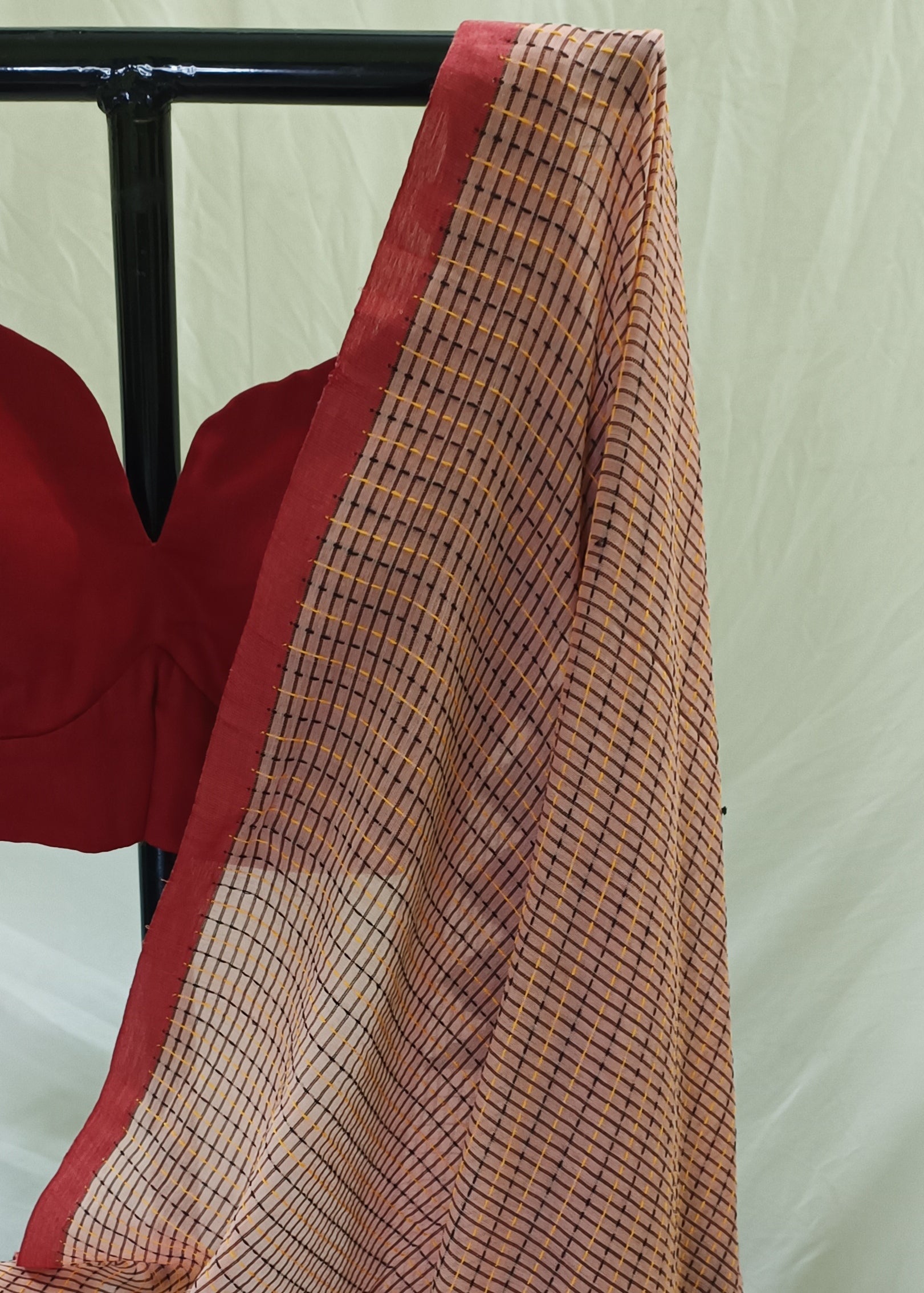Red blouse with a checkered scarf draped over it on a white background