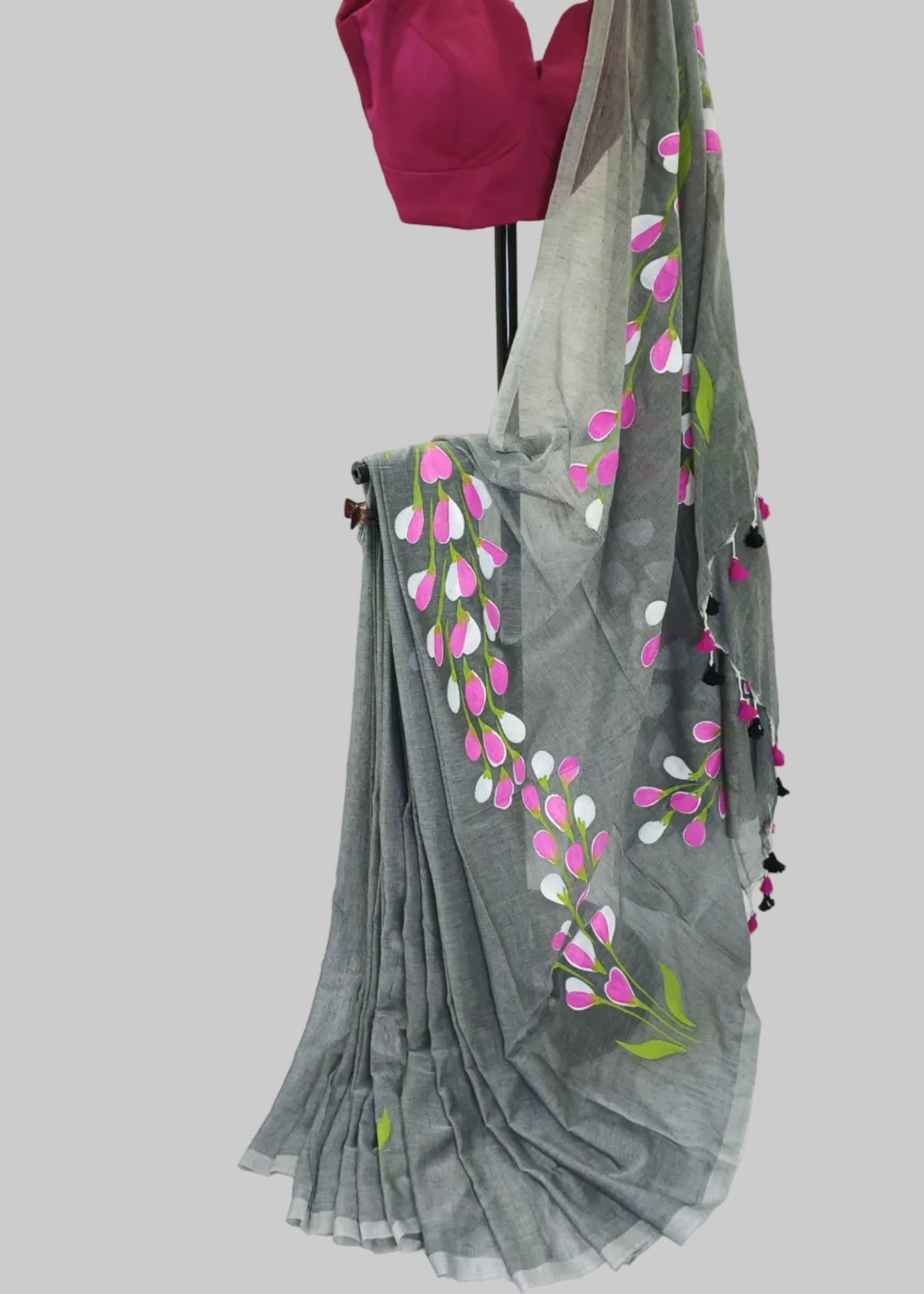 Gray saree with floral patterns draped over a mannequin against a white background