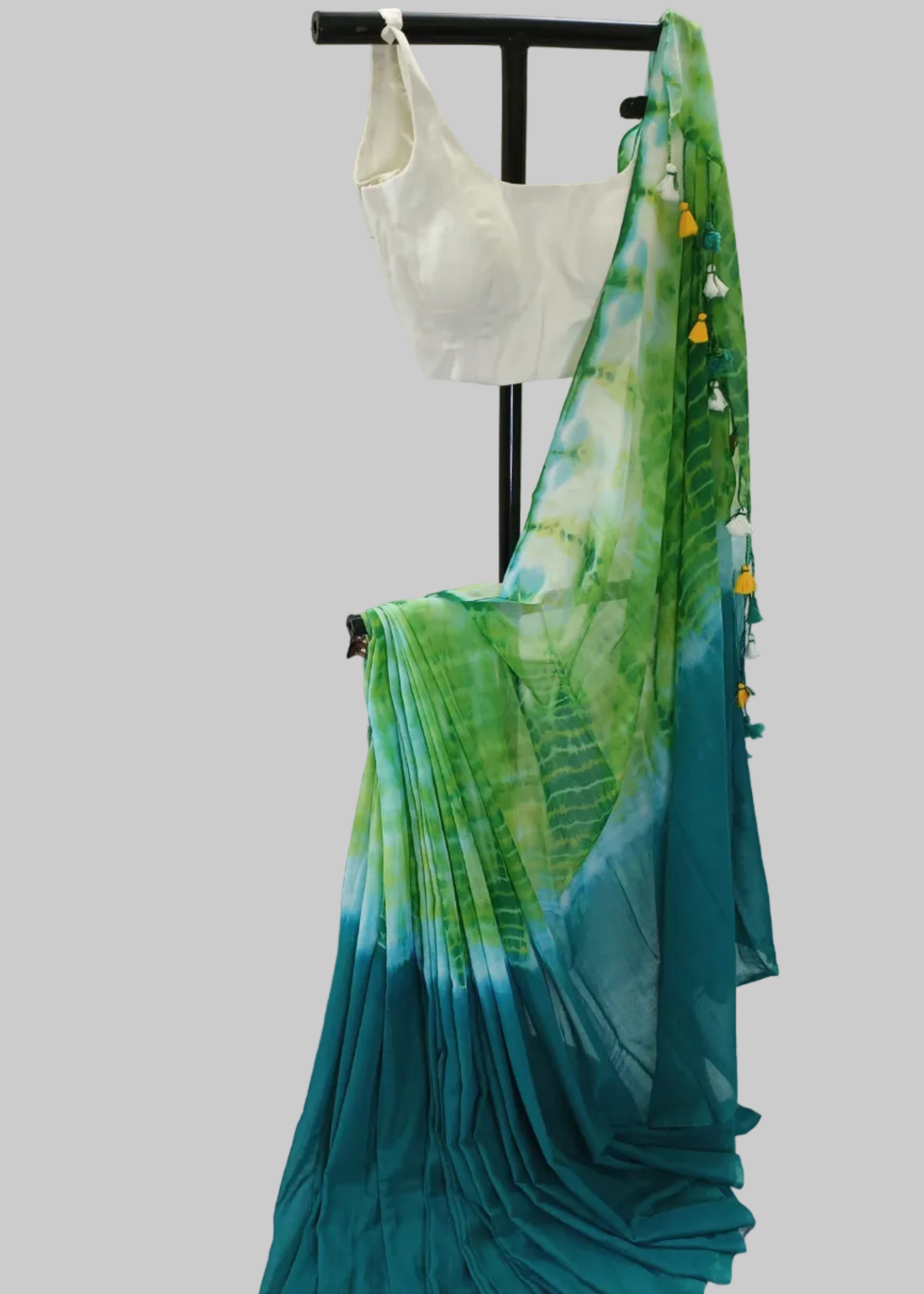 Green and blue gradient saree with a white blouse on a white background