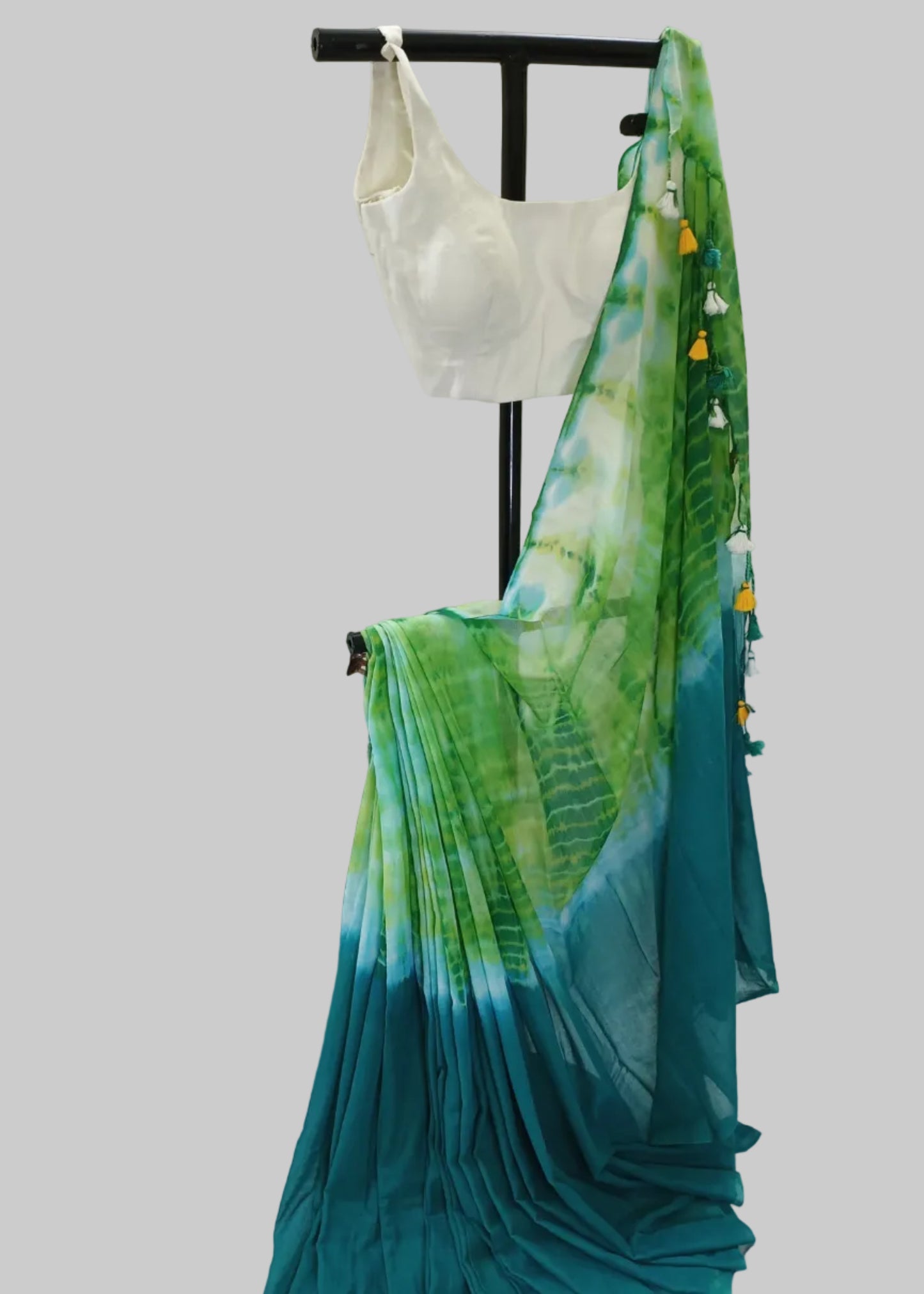 Green and blue gradient saree with a white blouse on a mannequin against a white background