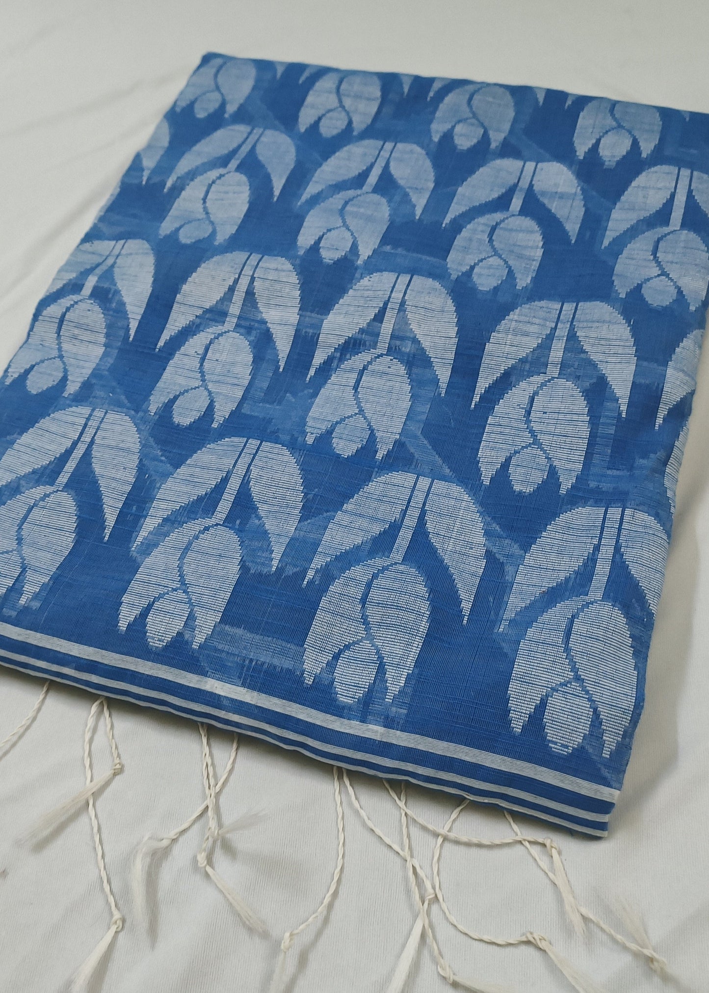Blue and white patterned saree with fringes on a white background