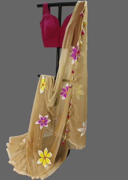 Beige saree with floral designs on a stand against a plain background