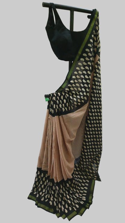 A black and beige patterned saree with a black blouse displayed on a stand against a white fabric backdrop.