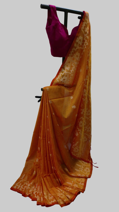 An orange and yellow tie-dye saree with a matching magenta blouse, displayed on a black clothing stand against a draped white fabric backdrop.